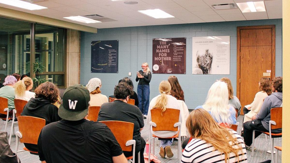 A student reads their poem in front of an audience in the Wick Poetry Corner at 91�ֿ�.