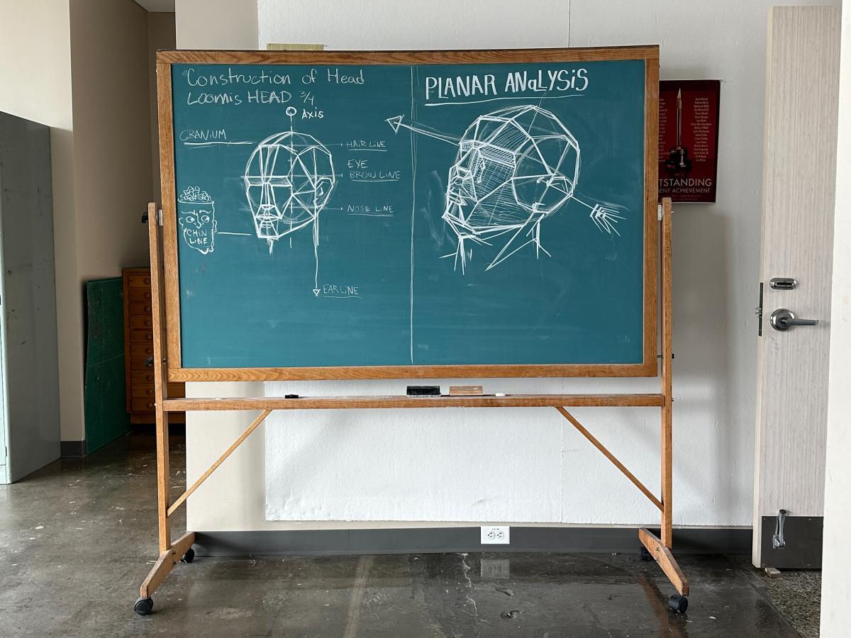 Chalk board with sketches of two heads