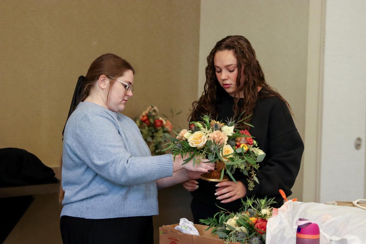Fockler Leshon and a student prepare a floral arrangement.