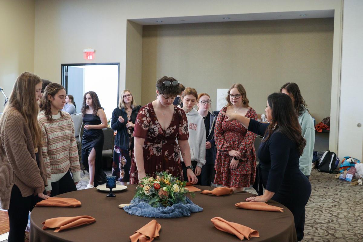 Students check to make sure every tablescape is perfect. 