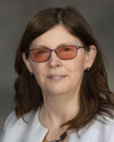 Head-and-shoulders portrait of a woman in professional attire with a neutral background.