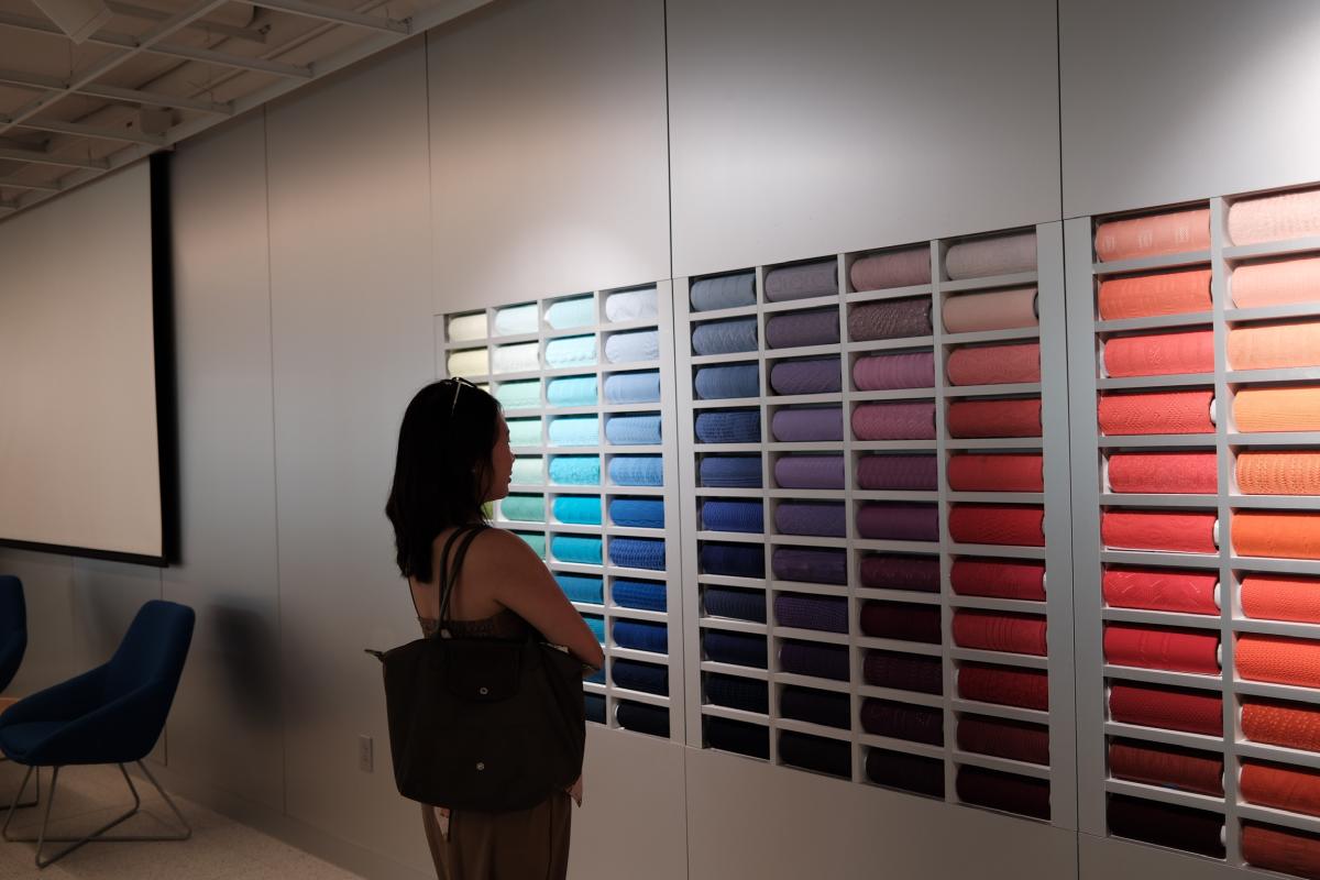 Anna in front of multicolored fabric samples.