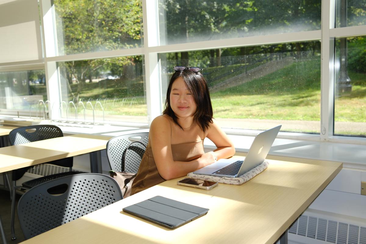 Anna sitting at a table with her computer.