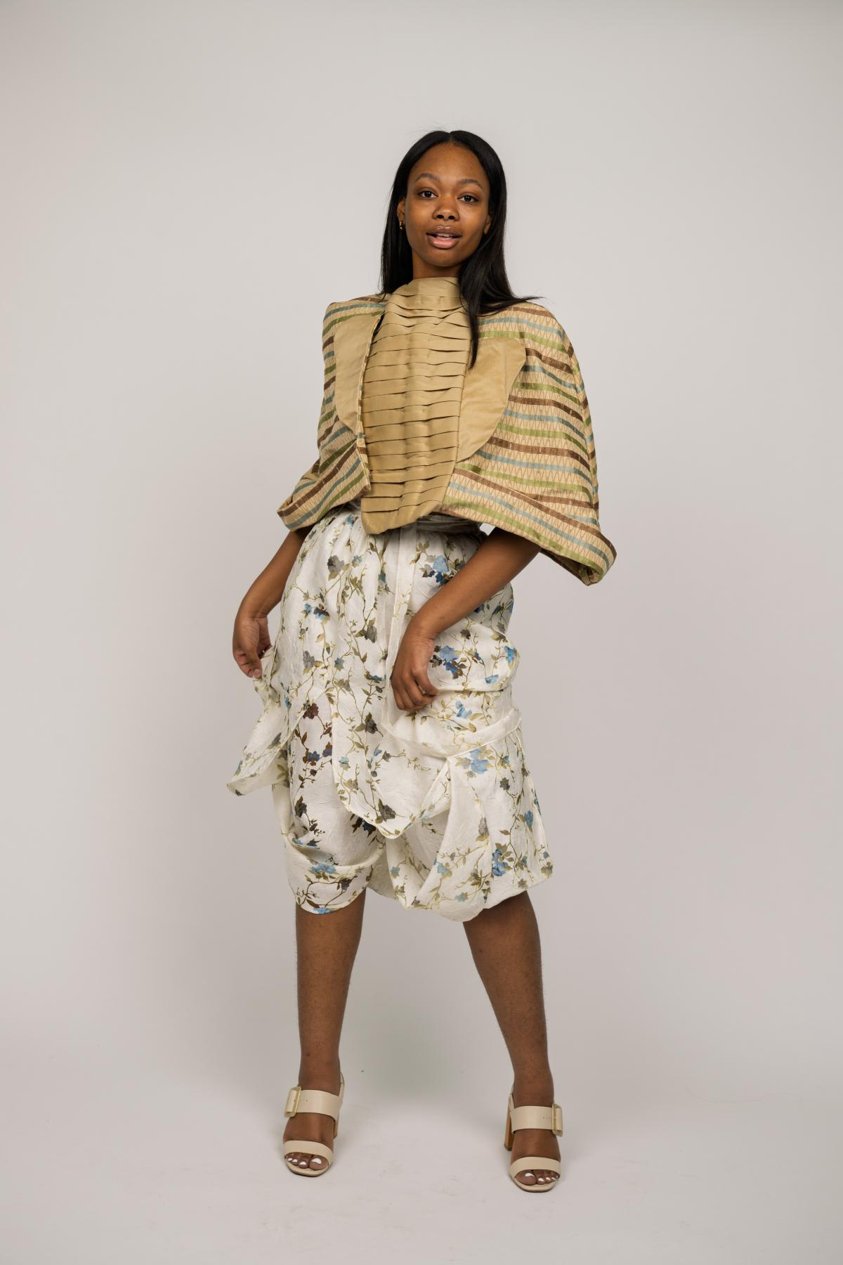 a models wears floral skirt and geometric jacket