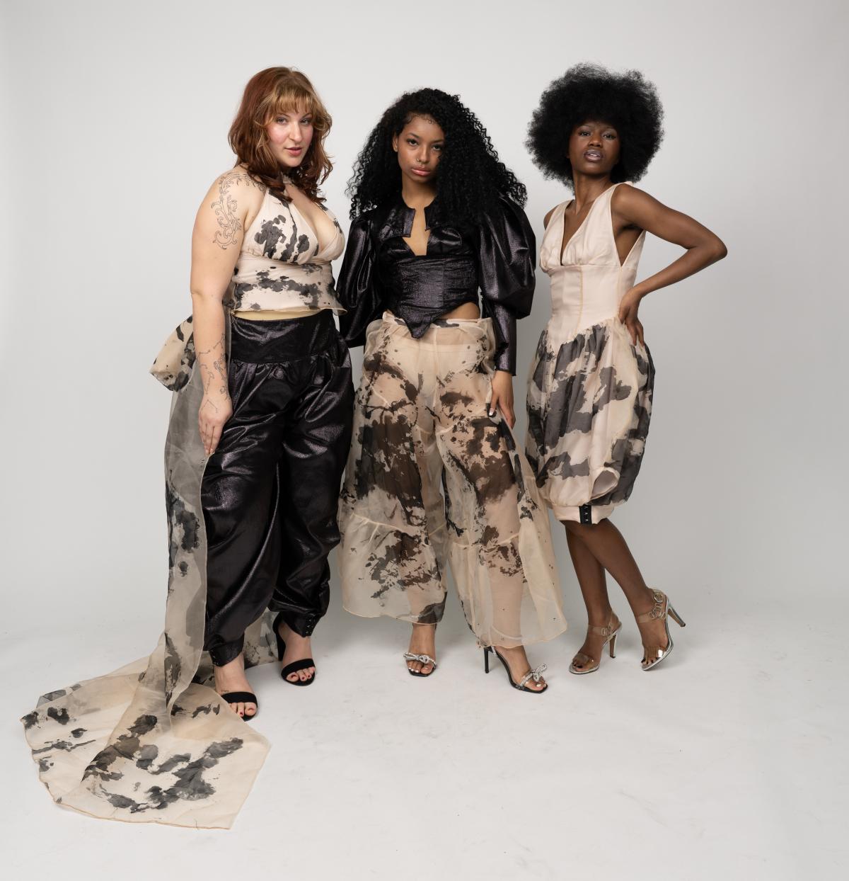 three models wear custom designs with a paint splatter patterned fabric. one garment is a dress while the other two are matching set 