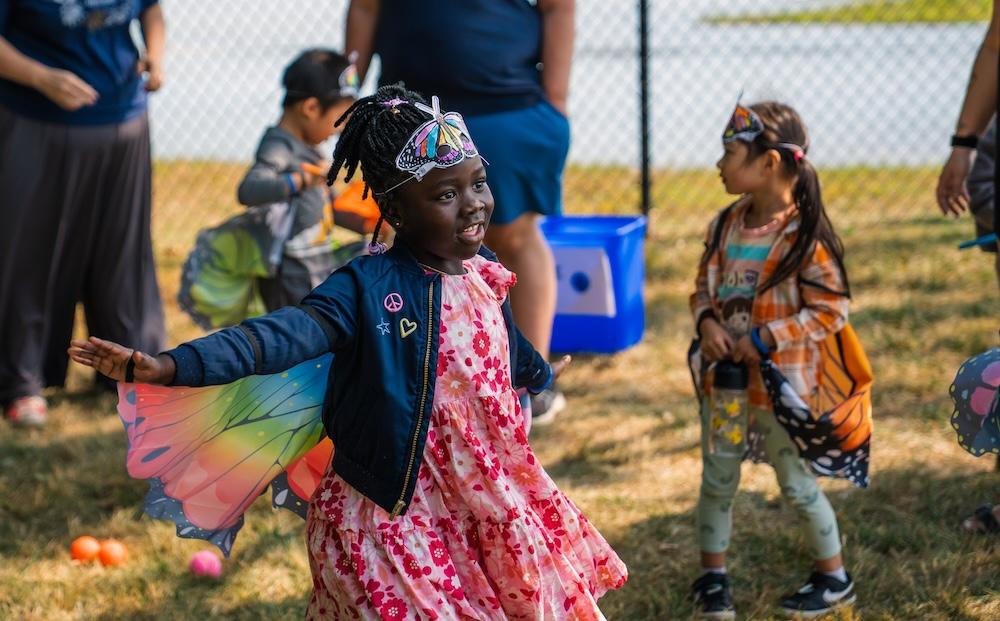 CDC child runs with butterfly wings at BeeCampus USA event
