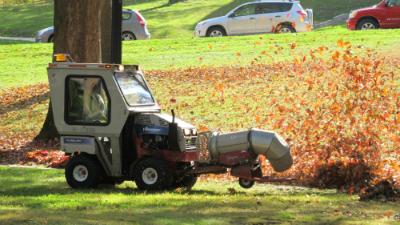 91�ֿ� Equipment Blowing Orange Fall Leaves across the green lawn