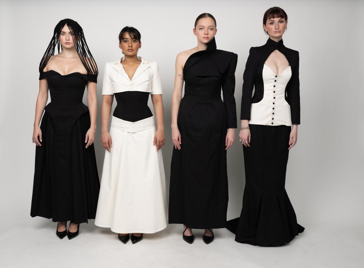 four models wear black and white avantgarde dresses. the dresses feature corsets and angular shoulders