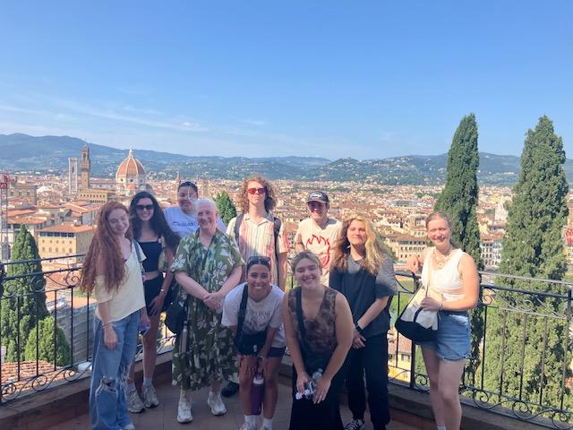 Cone and her students in the Rose Garden in Florence with a view of the city behind them.