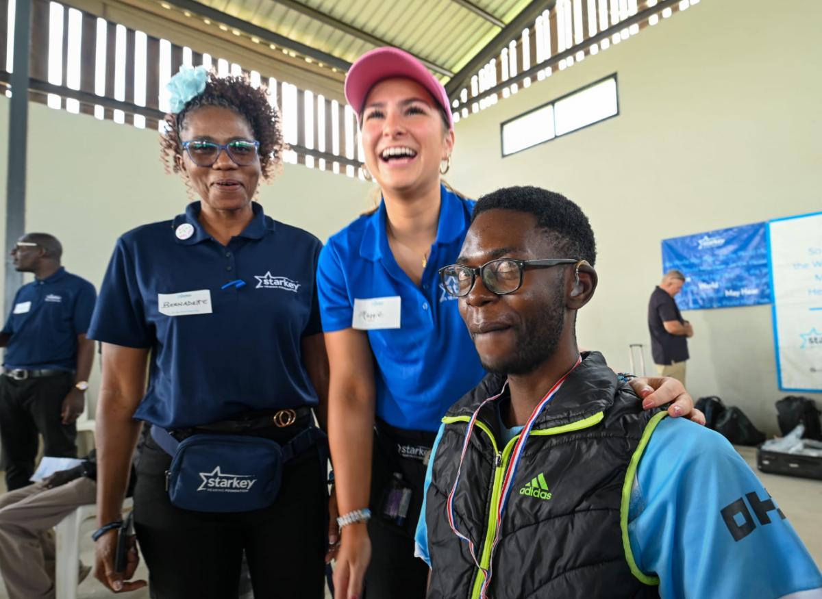 McCullough with a hearing patient and an institute staffer.