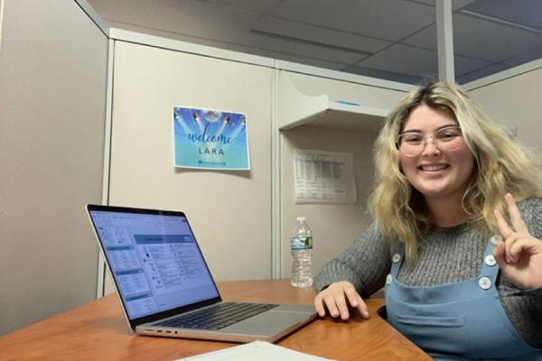 EMAT student Lara Kilchenmann sitting at table with laptop