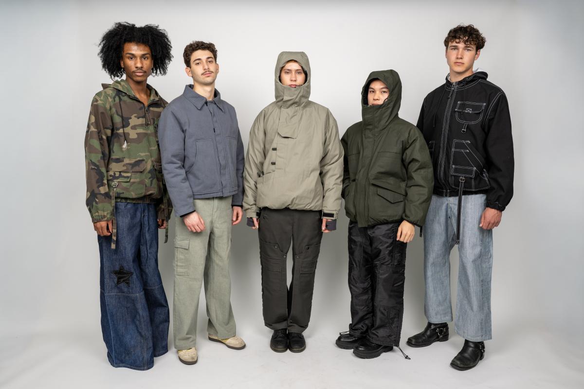 several models wear custom trousers and long sleeve shirts in earth tones