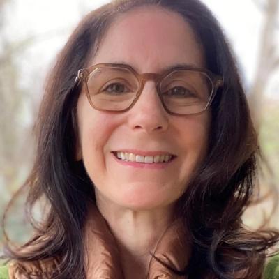 Professional headshot of white woman with dark brown hair and glasses