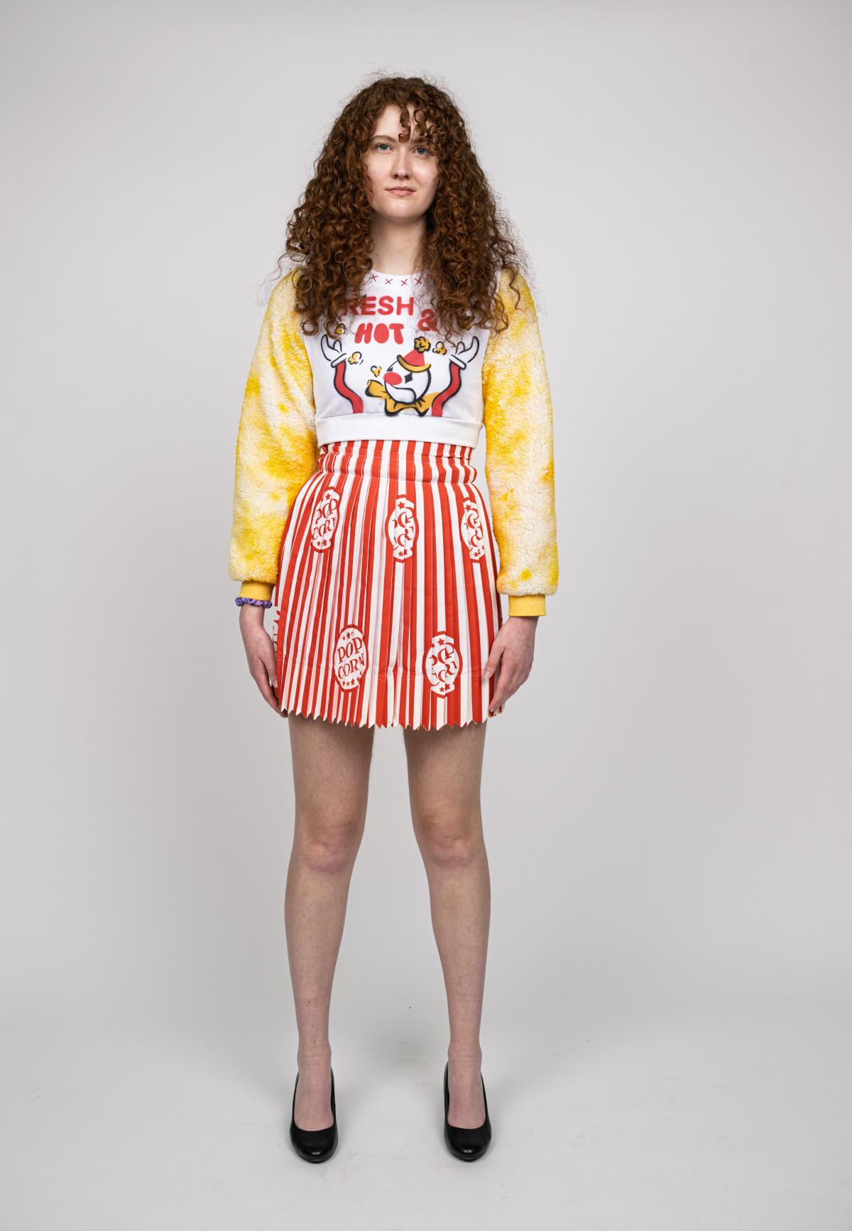 a model wears a long sleeve popcorn themed dress 