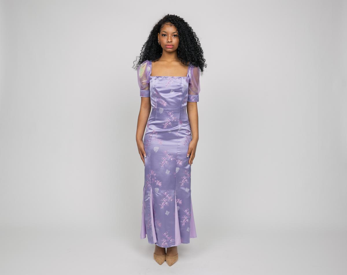 a model wears a long form-fitting lavender dress with cheer balloon short-sleeves
