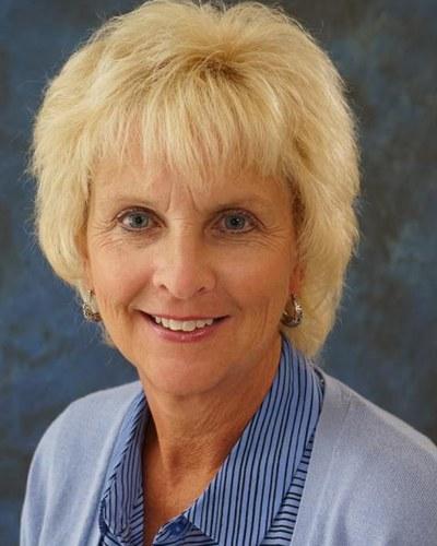 Professional portrait of a woman facing the camera against a neutral background.