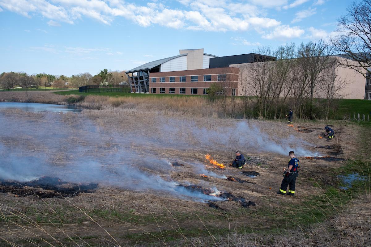 City of Kent firefighters light a blaze in the prairie grass during the annual controlled burning of the prairie. (Photo credit: Bob Christy)