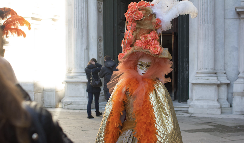 Person in bright orange costume in Italy