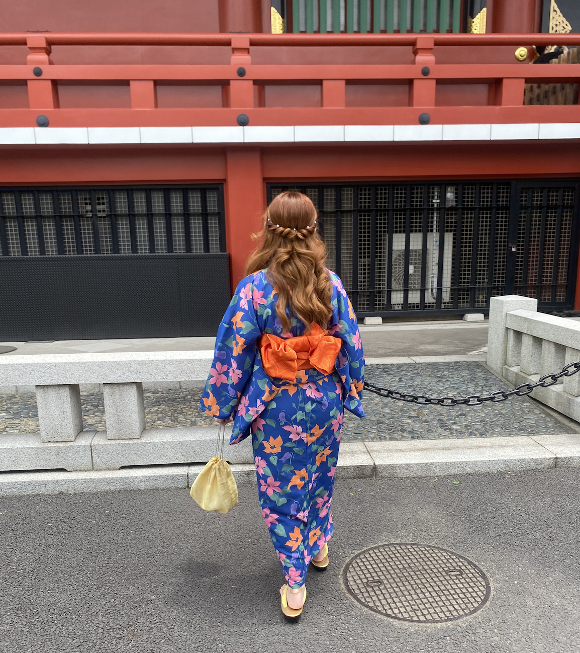 Ana Ligia dressed in a kimono and walking toward a building.
