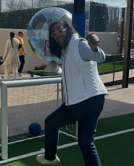 Betsy Ann kicking a ball into a mini soccer goal