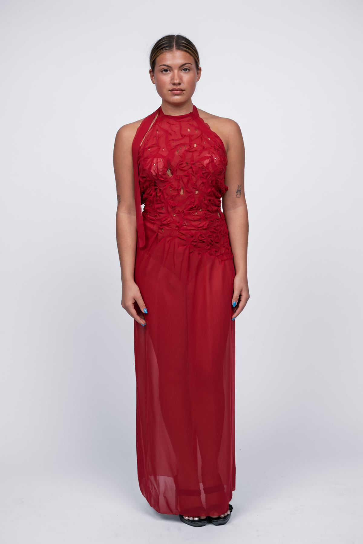 a model wears a red sheer beaded gown
