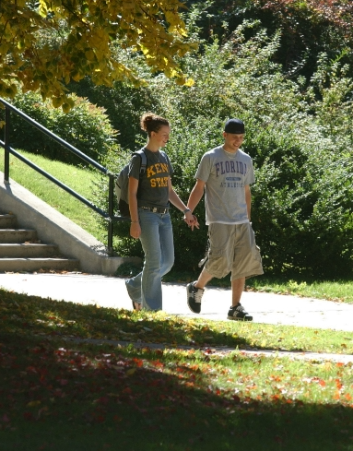 Two students walking hand in hand on campus