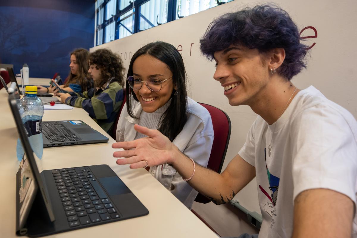 Students work on a laptop together in class