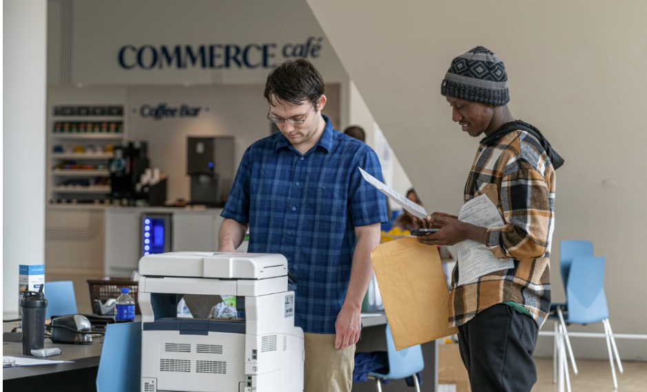 A student VITA volunteer and a taxpayer at the copy machine.