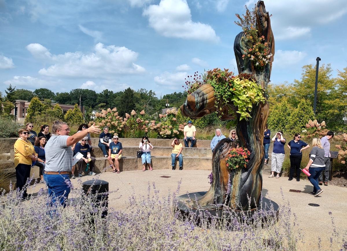 Rebekka Berryhill leading a tour group to the Seated Earth sculpture. 