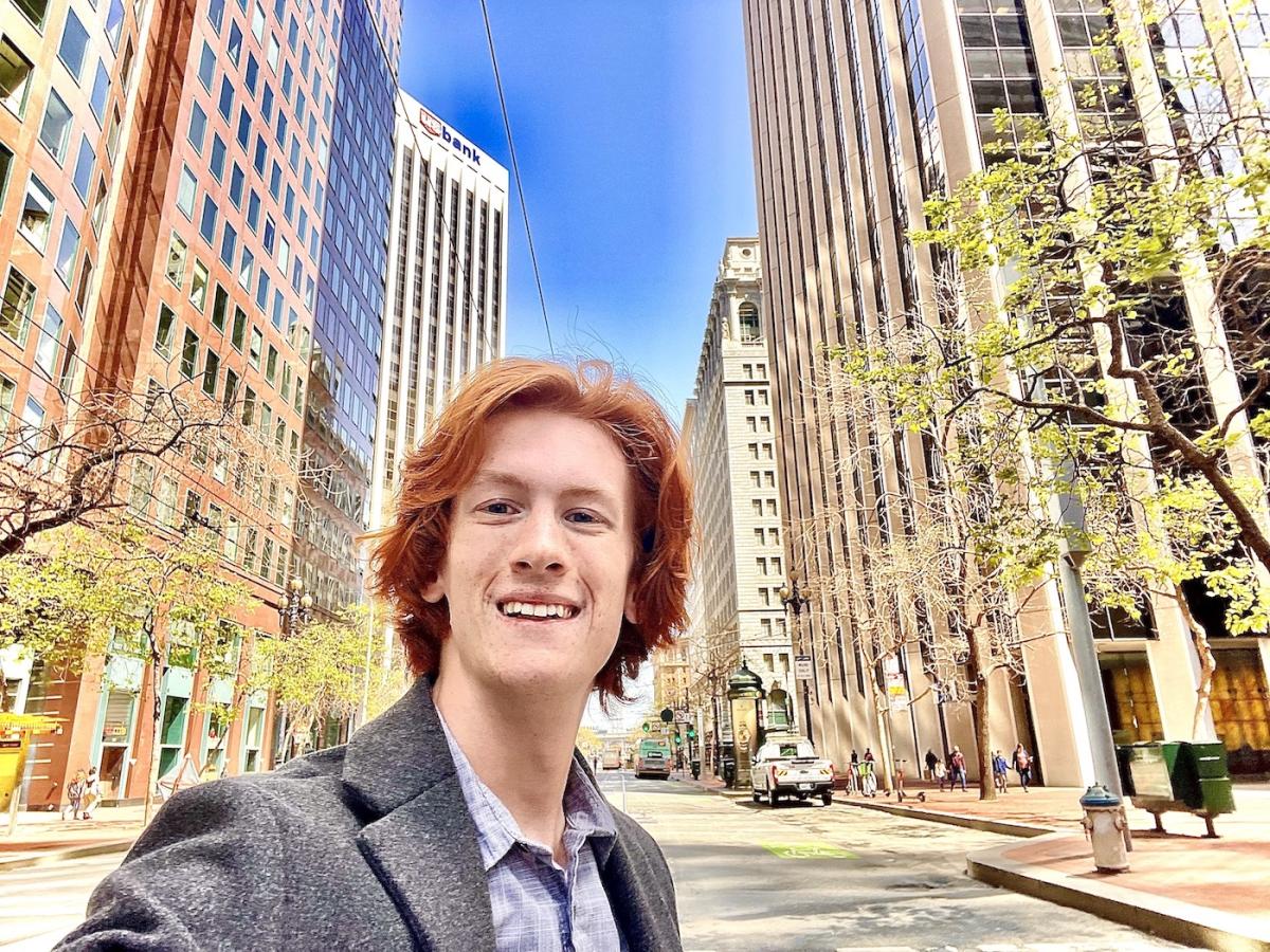 Head shot of freshman Honors College student William Dakin with city backdrop. 
