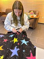 Zoey Almy making a blanket. Zoey Almy making a blanket.