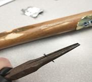 needle nose pliers holding nail