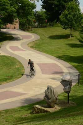 A single bike riding down a curved campus path