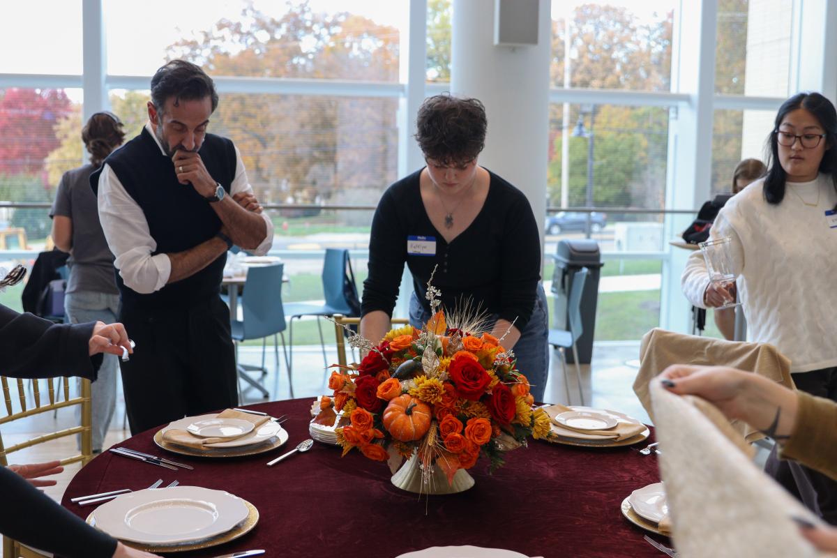 Joe Mineo surveying at tablescape in progress - HEM Design Challenge 2025