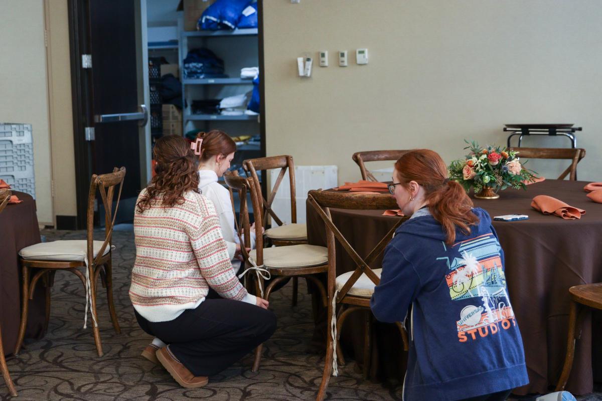 Students arranging tables and chairs for the reception.