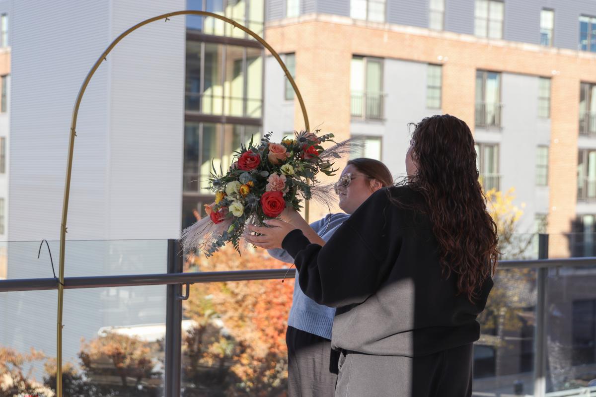 Fockler Leshon and Ulicney prepare some of the decor for the rooftop ceremony. 