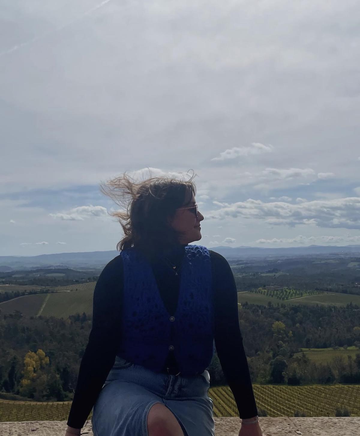 Ali at an overlook with the Italian countryside behind her.
