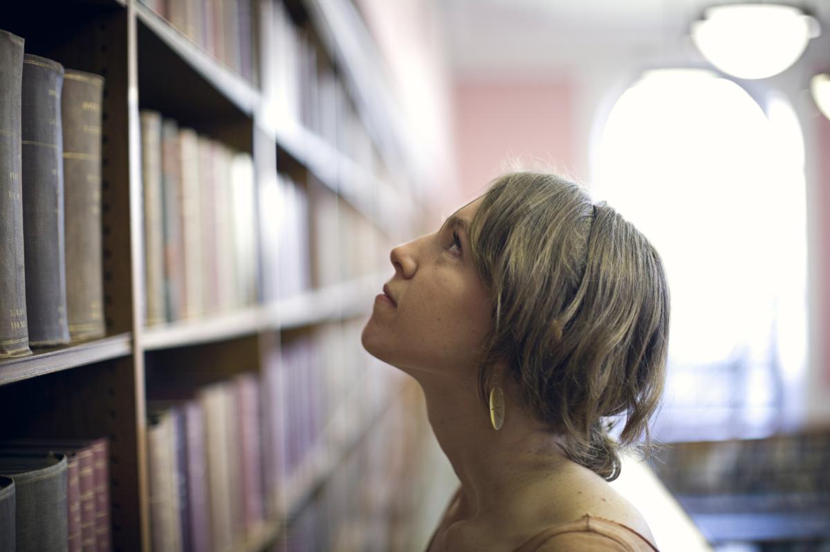 A student looks at a bookshelf of career guides and resources