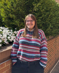 Outside headshot of Rebecca Nugent wearing a colorful sweater