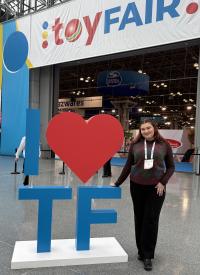 Sophia standing next to a structure that reads "I heart TF"