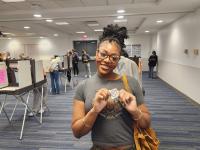 A student smiles having just cast her ballot in an on-campus polling location.
