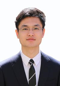 a young man with dark hair wearing a dark suit