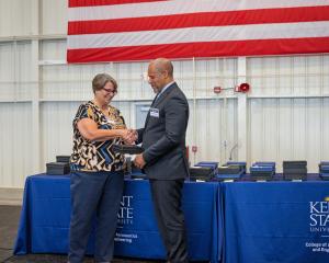 Past Dean Christina Bloebaum presents the Dean's Wings award to Lawrence Epps.