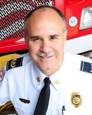 a man wearing a white uniform in front of a red truck