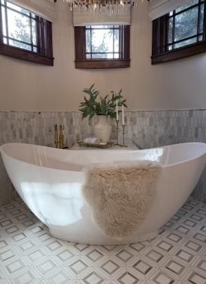 An above-ground white bathtub with a fur blanket draped over its side