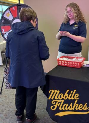 Madelyn working a promotional table for Mobile Flashes.