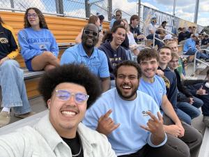 Stuart sitting with friends at a ����ԭ�� football game.