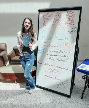 Loustella stands with her book