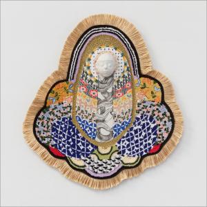 A multitude of patterns and textiles conjoin in a center point where a white sculpted face lies