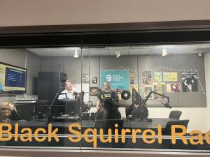 Student Media Director and UpwardBound students sit inside the Black Squirrel Radio Studio